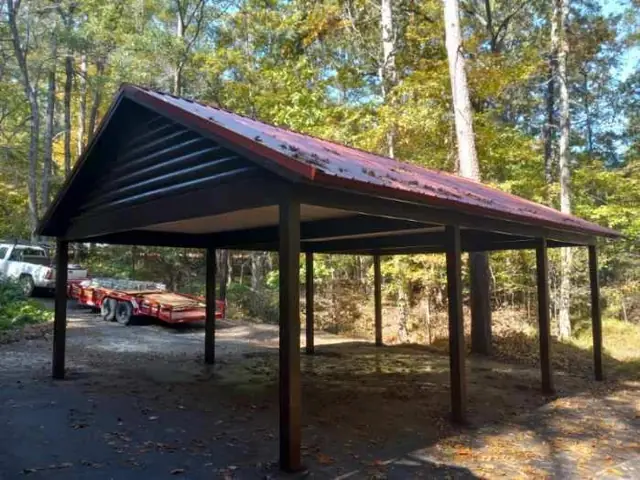 Timber-post carport with a metal roof on a wooded East Texas lot