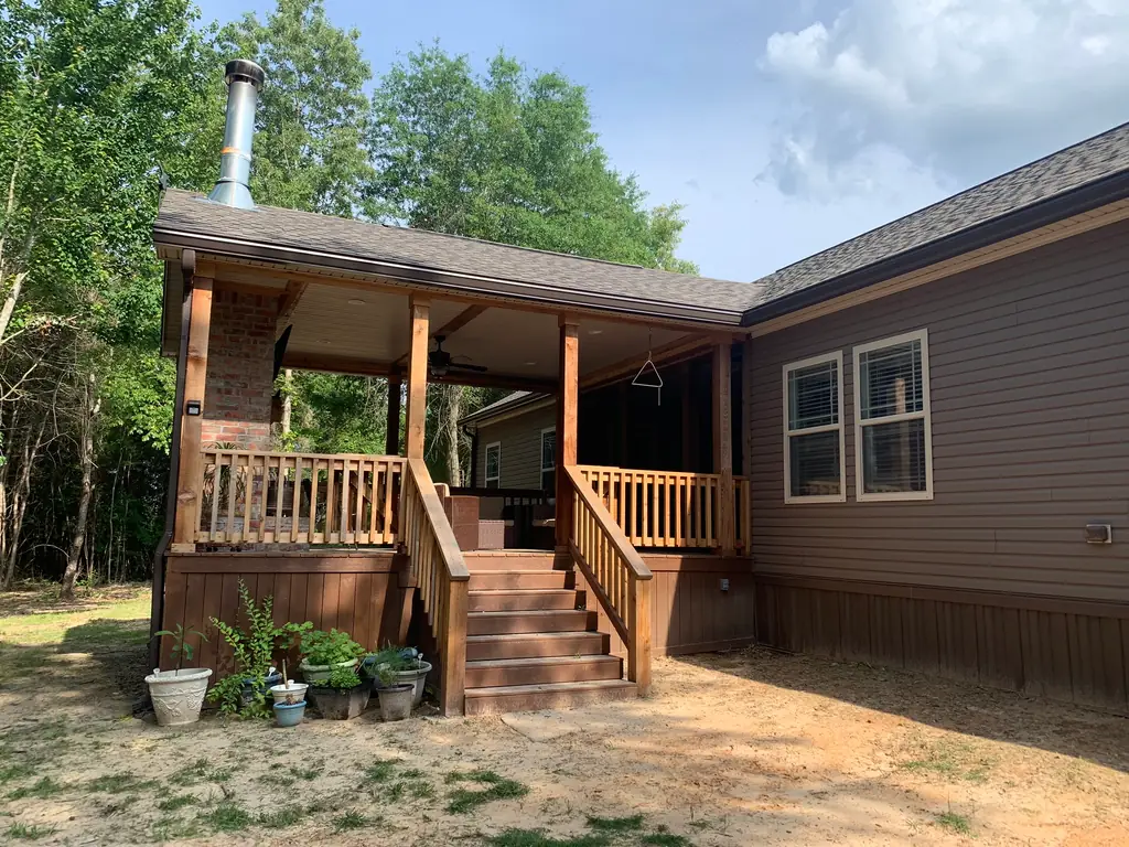 Cedar-post covered deck with a brick column and stained steps, built by Longview Decks